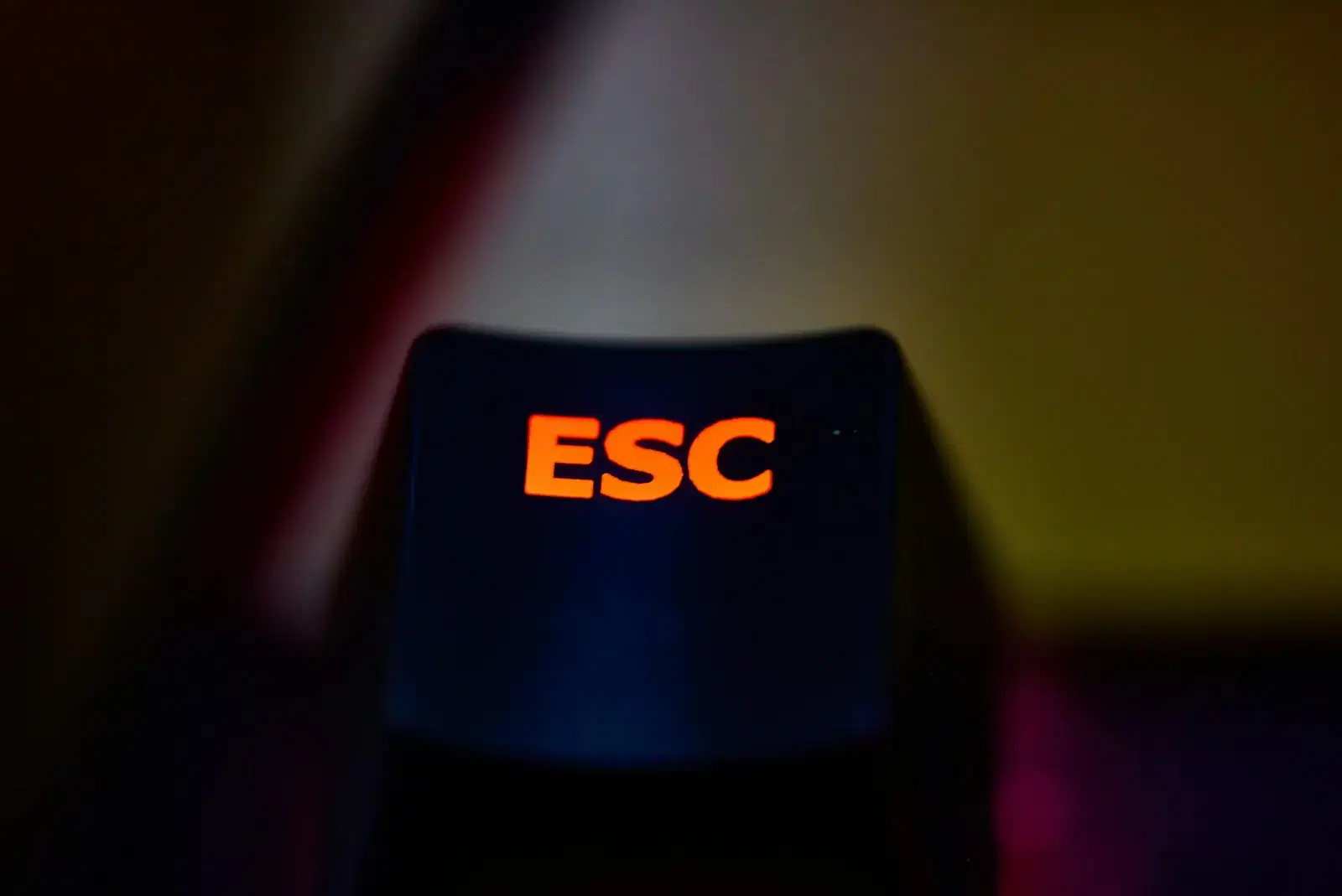 A dark keyboard key with an orange ESC legend